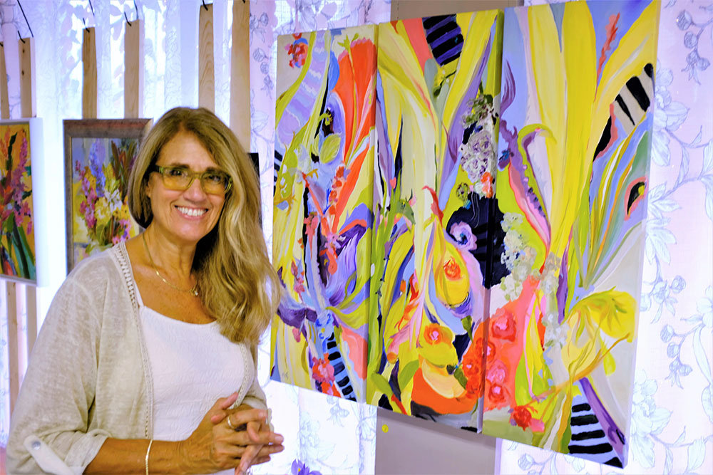 Highland Artist Beth Walters-Storyk stands beside one of her paintings, ‘Magical Garden Triptych’